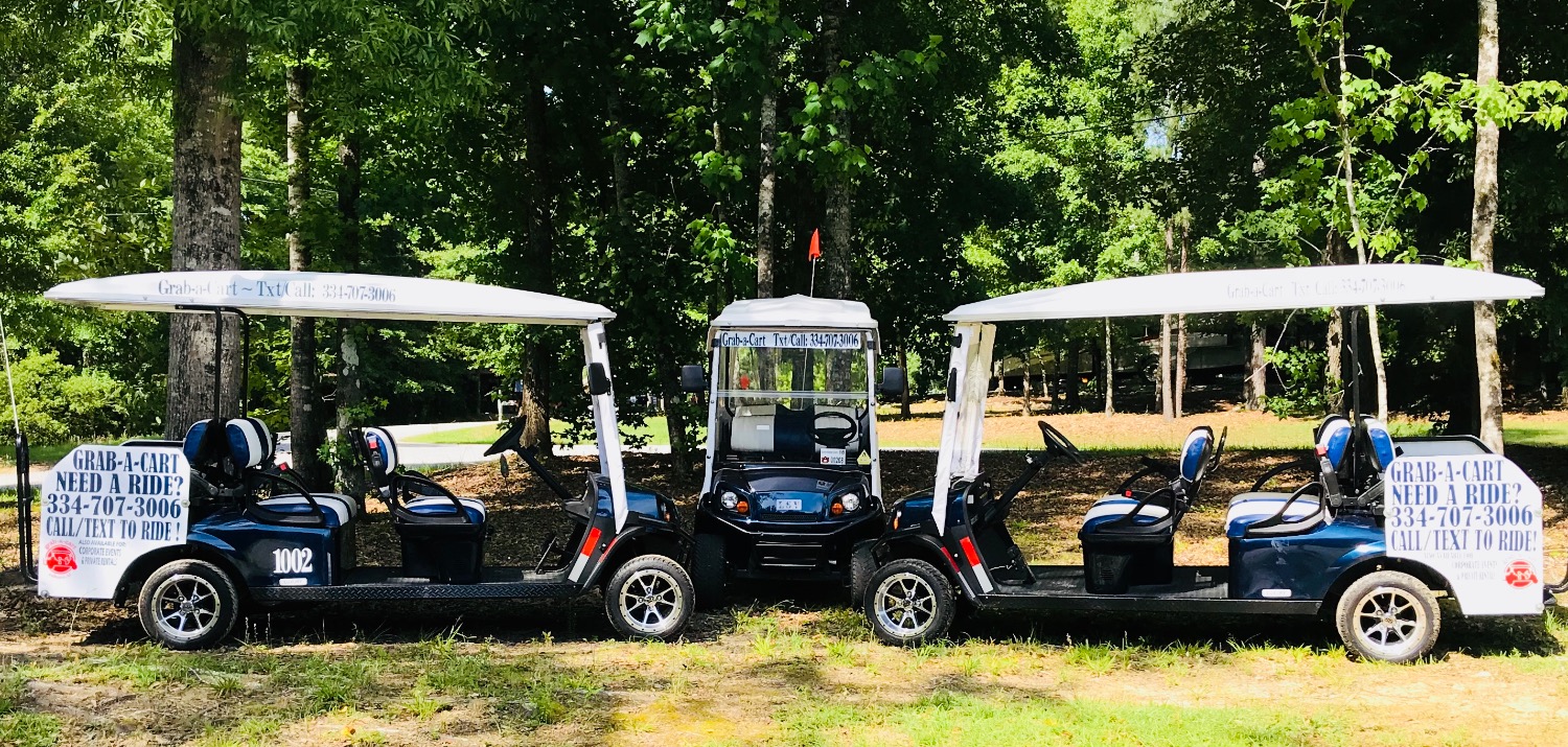 Three Grab-a-Cart shuttle carts parked under trees
